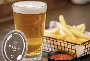 Niom Bistro house lager with a basket of fries