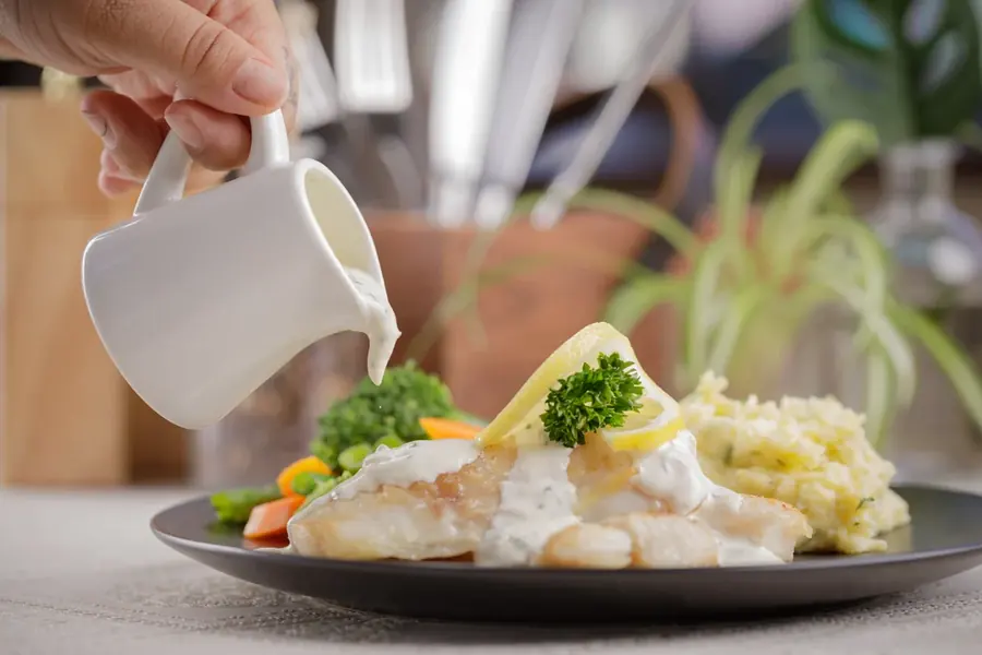 Fish with creamy sauce, mash and vegetables at Niom Bistro